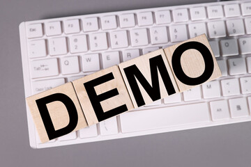 demo, text on wood cubes on white keyboard and gray background
