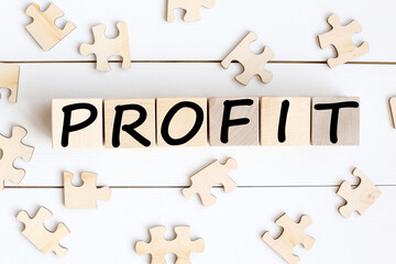 Obraz premium profit. text on wood cubes on white background near puzzles