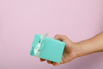 hand holding a gift box being delivered to someone