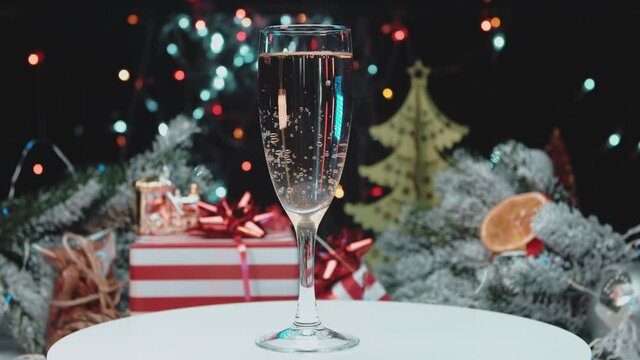 A glass of champagne with bubbles on the background of New Year's lights.Holiday concept.