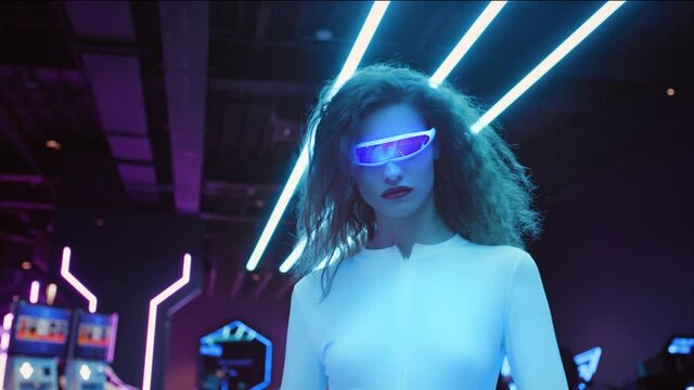 Fashion young woman in futuristic glasses and white suit walk in night club in city. Blue and violet neon lights. AR hybrid reality, future technology, augmented reality, entertainment, sci-fi concept