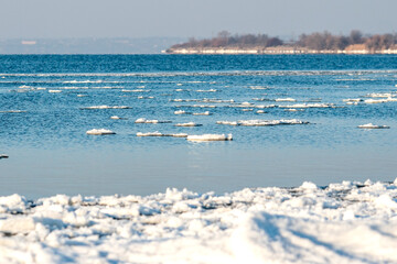 Ice floating on water in a reservoir. Sunny weather