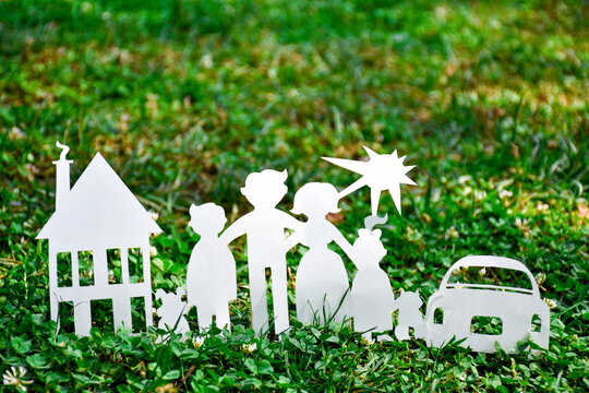 Paper family, house and car on a green grass. Family Life Insurance, protecting family, family  and love concepts. Concepts saving money for house or car. Mortgage and auto lending. Ecology concept. 