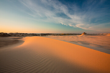 Moving dunes in the Słowiński National Park during sunset. Amazing textures on sand bathed in golden light.
