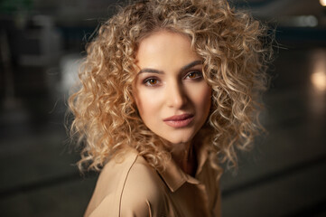 portrait of a beautiful young girl with curly hair looking at the camera