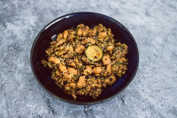 Obraz na płótnie Canvas plant-based food, vegan potato mushroom and zucchini stir fry with alomnds and sesame seeds