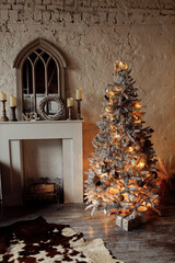 Photo of Christmas tree with lights and balls, garland and presents, near the fireplace. Cozy decorated room. Winter holidays, xmas background, interior design concept