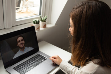Attractive young female having a video call with a colleague while working from home during coronavirus outbreak