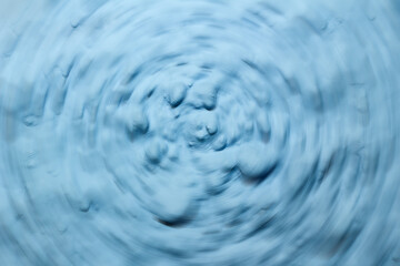 Blue Vortex Round. Optical art. Blue painted background, blue textured wall. Artistic plaster. Abstract pattern.