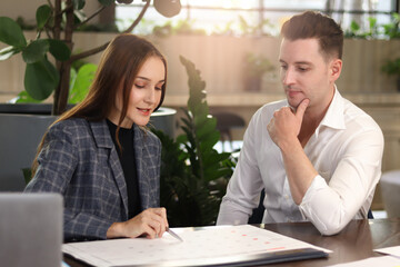 Happy colleague talking while sitting at lobby of modern office or coffee shop, attractive business partner working together, having conversation and discussion about work project