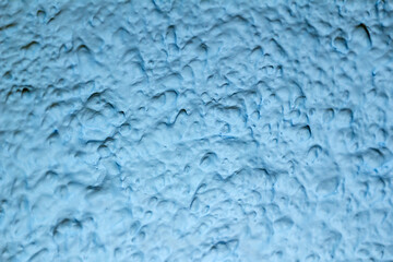 Blue painted background, blue textured wall. Artistic plaster. Abstract pattern. Blurred edges.