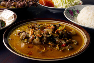 Tongseng Kambing, is a spicy curry made from goat meat, in shallow focus and blurred background.
