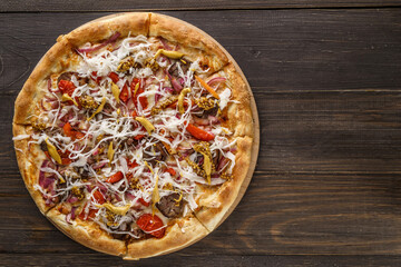 Fresh pizza with tomato sauce, black olives, mozzarella cheese, ham on wooden table closeup. Space for text or copy space. Pizza menu. Restaurant menu advertise
