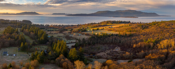Aerial View of the West Side of Lummi Island, Washington. The rural landscape of Lummi Island is highlighted by a beautiful sunrise with Orcas Island in the background.