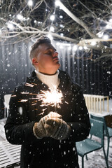 Guy with sparklers in winter at night