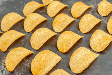 Horizontal view of delicious homemade chips laid on gray background