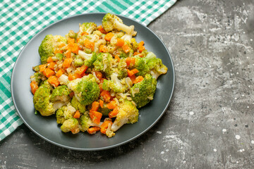 Fresh and healthy vegetable salad on green stripped towel on gray background