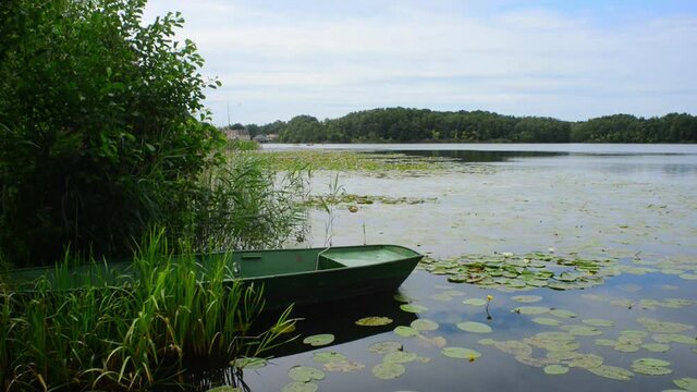 Scenic view in Lychen, Germany, Oberpfuhlsee with a green boat, in distance canoe and watersport 