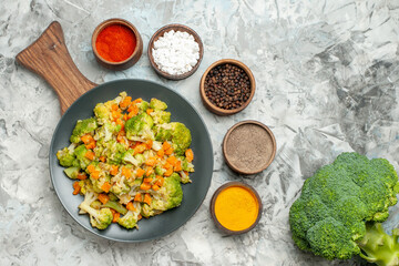 Fresh and healthy vegetable salad on wooden cutting board and spices on white background