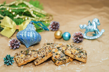 Shortbread cookies with different seeds and Christmas decorations on crumpled paper. Selective focus