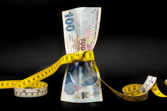 Turkish lira is tightened with measurement tape. Turkey's lira crisis. Turkish lira is going down and losing weight. Turkish economy plunges, crashing. Inflation, debt and tariffs concept.