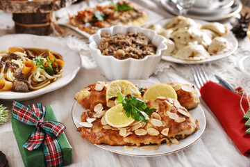 Christmas Eve supper with fried carp and other traditional dishes on festive table
