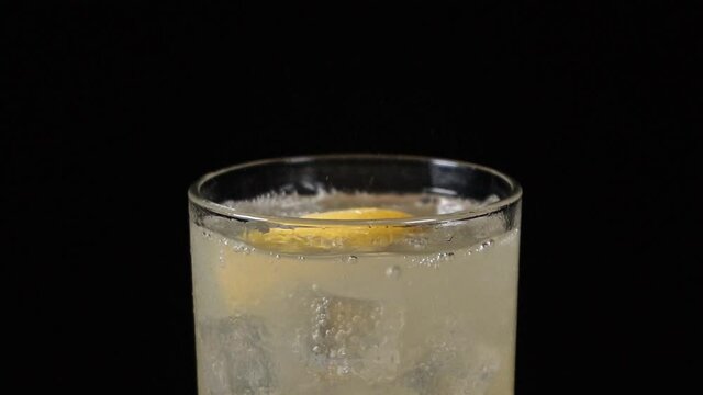 pieces of lemon falling into glass