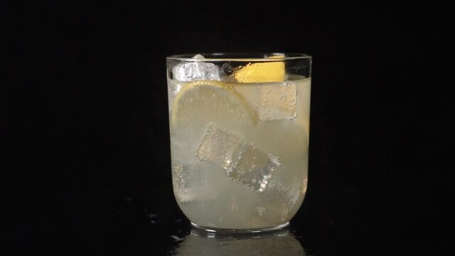 delicious lemonade spinning around with black background (slow motion)