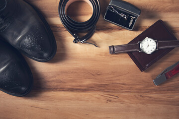 Men leather accessories on the wooden background.