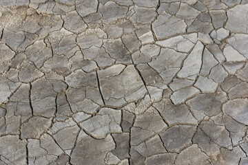Grey cracked dried soil textured background from mud volcanoes park