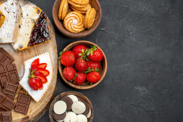 top view cake slices with fruits cookies and choco bars on a dark background sweet pie fruit