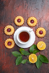 Fototapeta na wymiar top view cup of tea with little cookies on a dark background biscuit sweet dessert