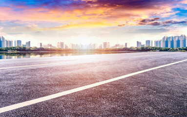 Obraz premium An empty asphalt highway straight ahead to a modern city.