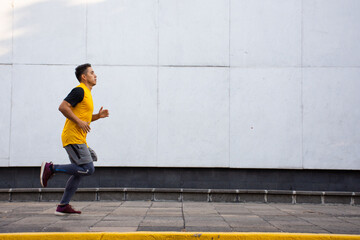 Young athletic man running on the street