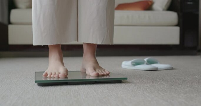 Woman stands on scale to measure her weight