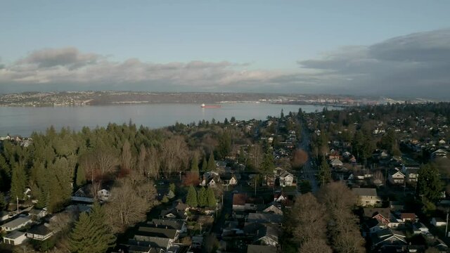 Drone Flying Over Peaceful Town With Seascape In Background At Proctor District, North End Tacoma, Washington. - Aerial Shot 