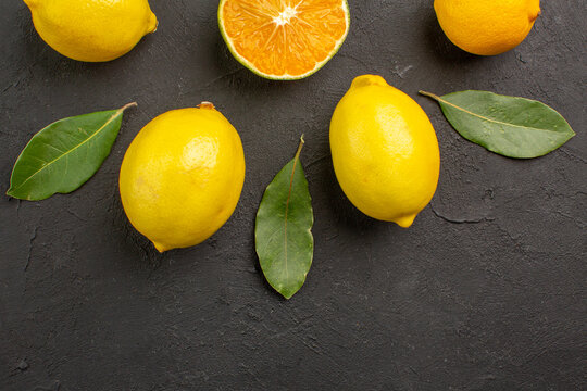 top view fresh sour lemons lined on dark desk citrus lime yellow fruit