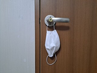 Disposable mask hanging on the doorknob