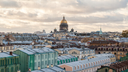 Fototapeta na wymiar The dome of St. Isaac's Cathedral rises above the rooftops of St. Petersburg
