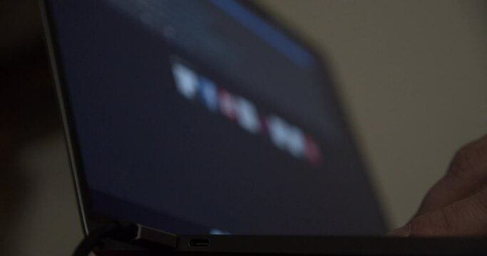 Close up of a male hand using a search engine on a laptop with blurry christmas results on the monitor