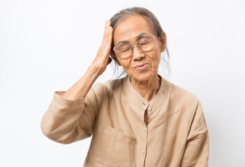 Old asian woman touch her head feel headache standing on white background.