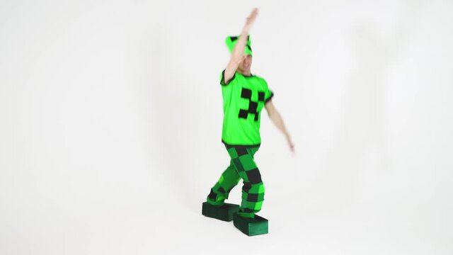 Portrait of a young cheerful man in a beautiful green suit with black patterns of squares on a white background. Animator in costumes. Entertainment for children. 4K video