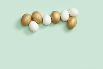 Top view easter composition with white and golden eggs, creative spring holiday flat lay with painted chicken egg