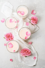 Moon milk drink glasses with roses on a concrete background. Top view.