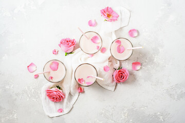 Moon milk drink glasses with roses on a concrete background. Top view.