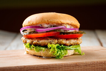 Closeup on chickenburger with pickles on the wooden board