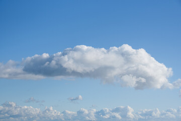 Tranquil blue sky with fluffy white clouds, as a nature background
