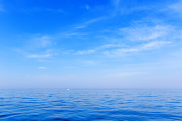 Beautiful relaxation background. A small white boat sits on a calm blue sea in clear weather. Calm at sea.