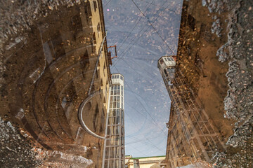Vintage building reflected in dirty puddle