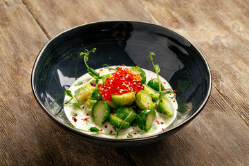 Brussels sprouts with caviar with creamy sauce in a black bowl